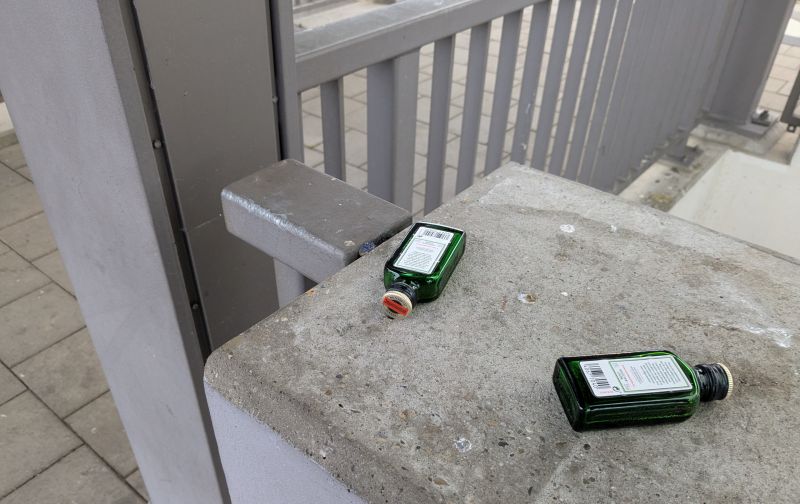 zwei kleine Flaschen Jägermeister, ausgetruneken, am Bahnhof